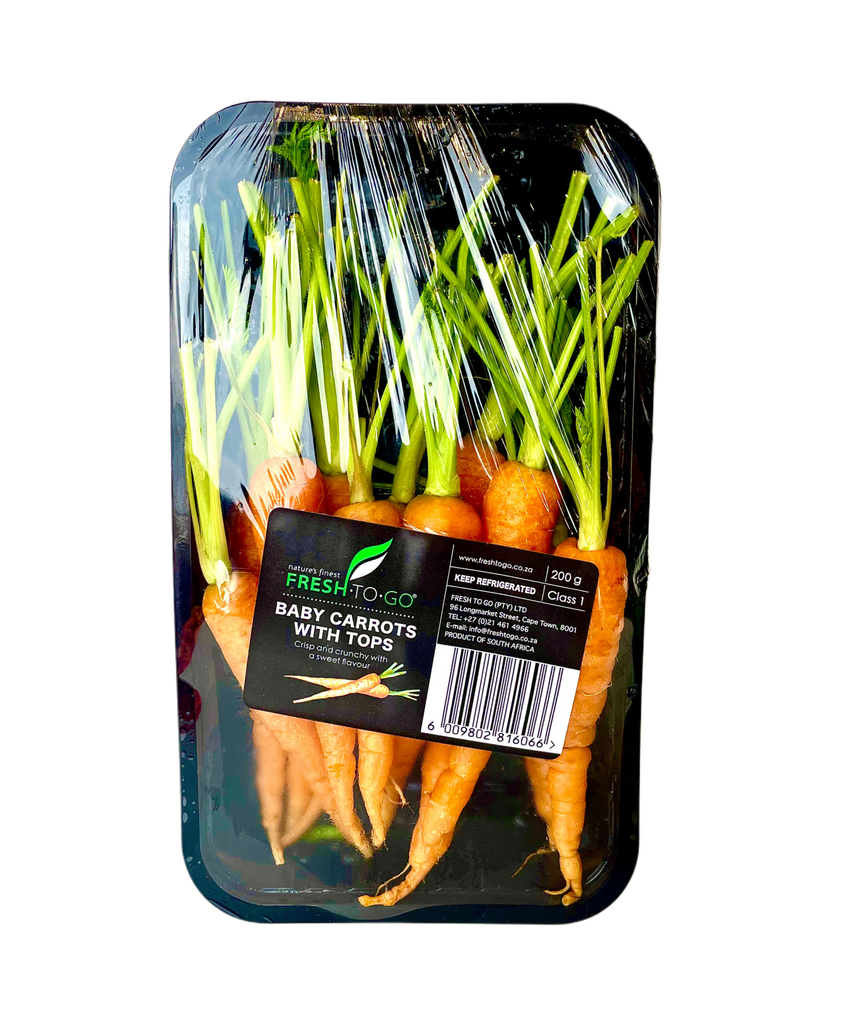 Packaged baby carrots with tops on a white background