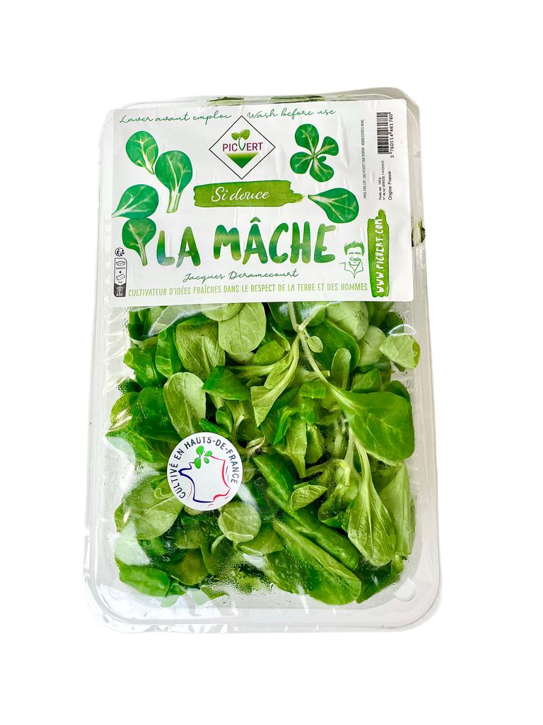 Packaged green leafy vegetables with a label on a white background